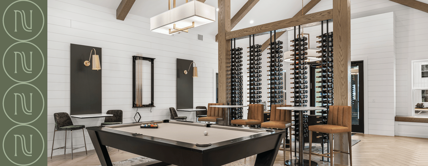 A billiards table in a clubroom with a wine rack wall in the distance 