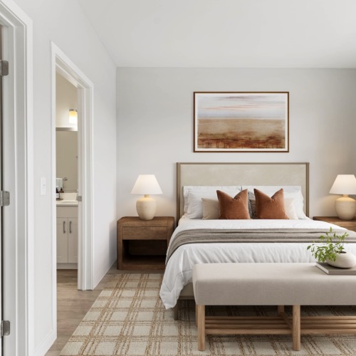 Staged bedroom with a bed, two end tables with lamps, a gingham rug, and bench 